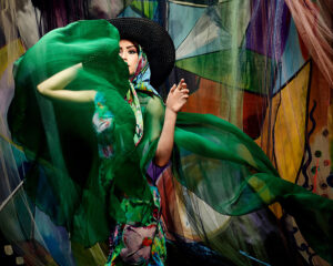 Fashion lookbook photo for silk print and clothing designer showing pretty model in a billowing cloud of colorful silk.