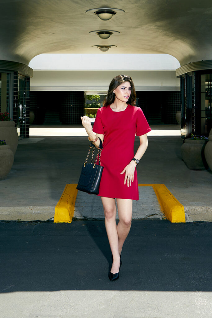 Campaign photo of pretty model in red minidress for easy-to-wear street to boardroom fashion designer.