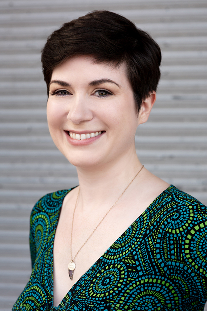 Professional Headshot for Real Estate Agent Professional headshot for young female real estate agent. Shot outdoors with studio lighting against corrugated commercial building wall as background.