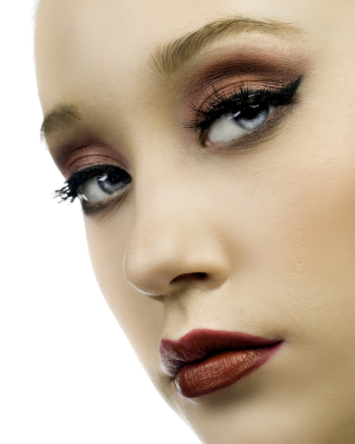Very tight closeup of beautiful blond model Sophie Heckman, in dramatic smokey-eye evening makeup. Ad for a beauty brand by Gerard Harrison, Houston fashion photographer.