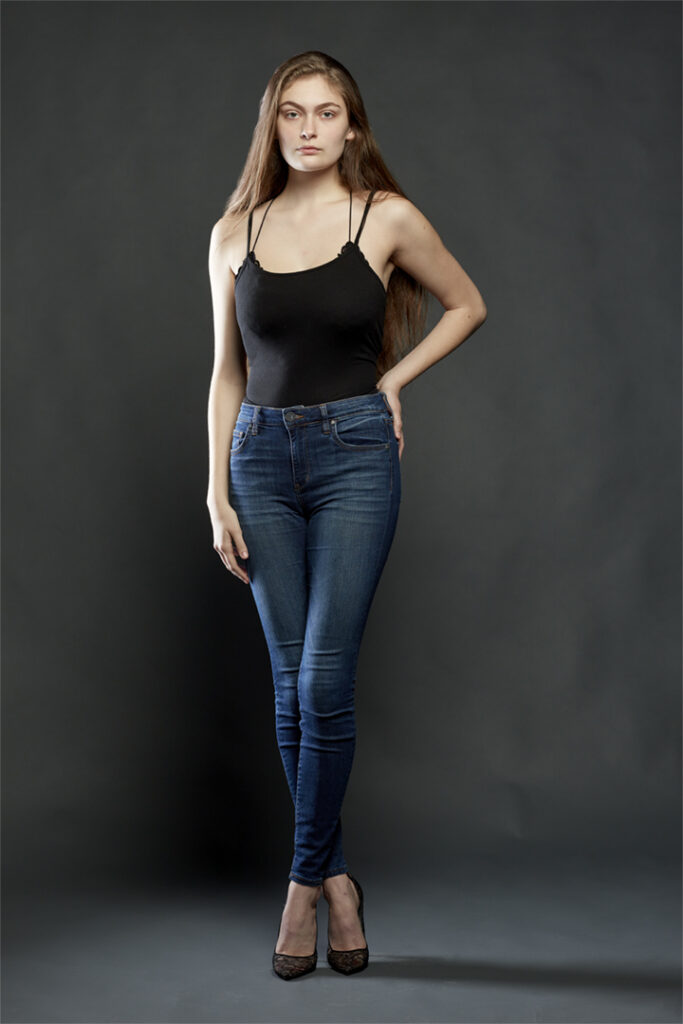 Portfolio shoot for fashion model Miranda Black. Denim jeans over body suit against dark background. Houston fashion photographer Gerard Harrison.