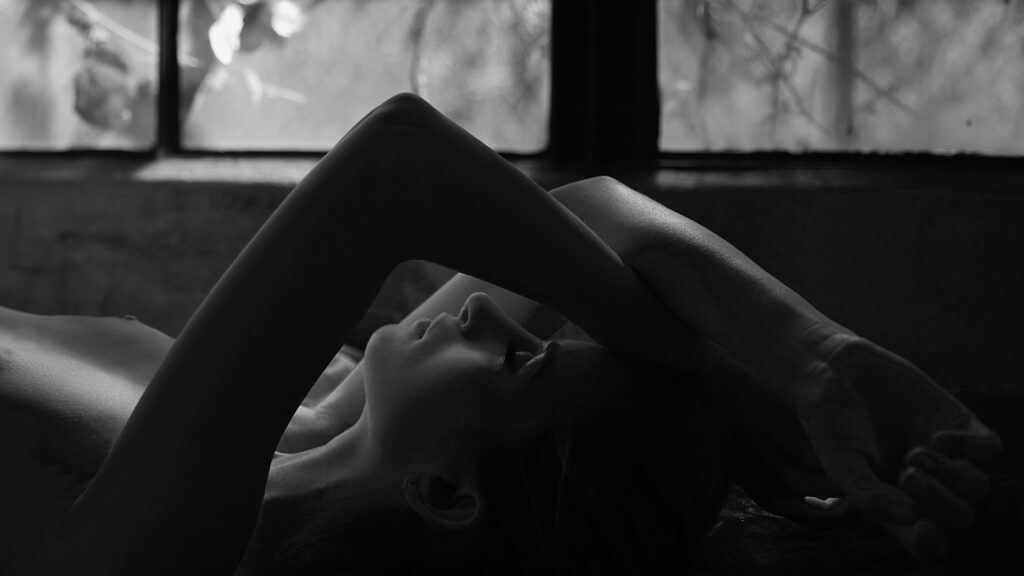 Reclining nude in black and white in front of window. Gerard Harrison, fine art photographer, Houston, Texas
